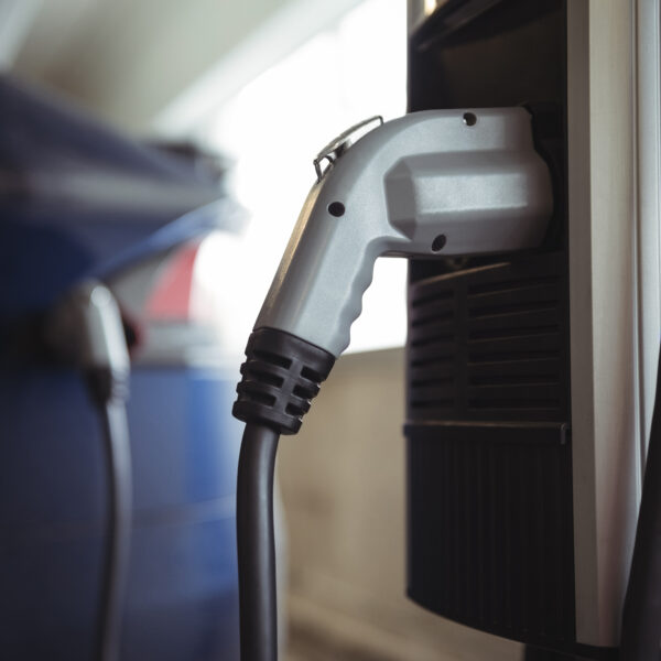 Close-up of car charger at electric vehicle charging station